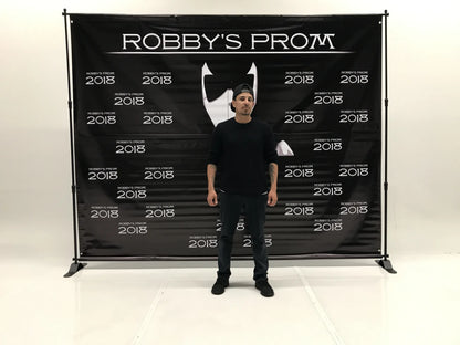 Man standing in front of an 8' x 8' Robby's Prom photo booth backdrop printed by Urban Tee LLC in South Gate, CA
