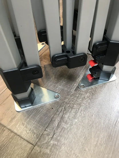Folded canopy frame legs with metal base plates and red locking pins