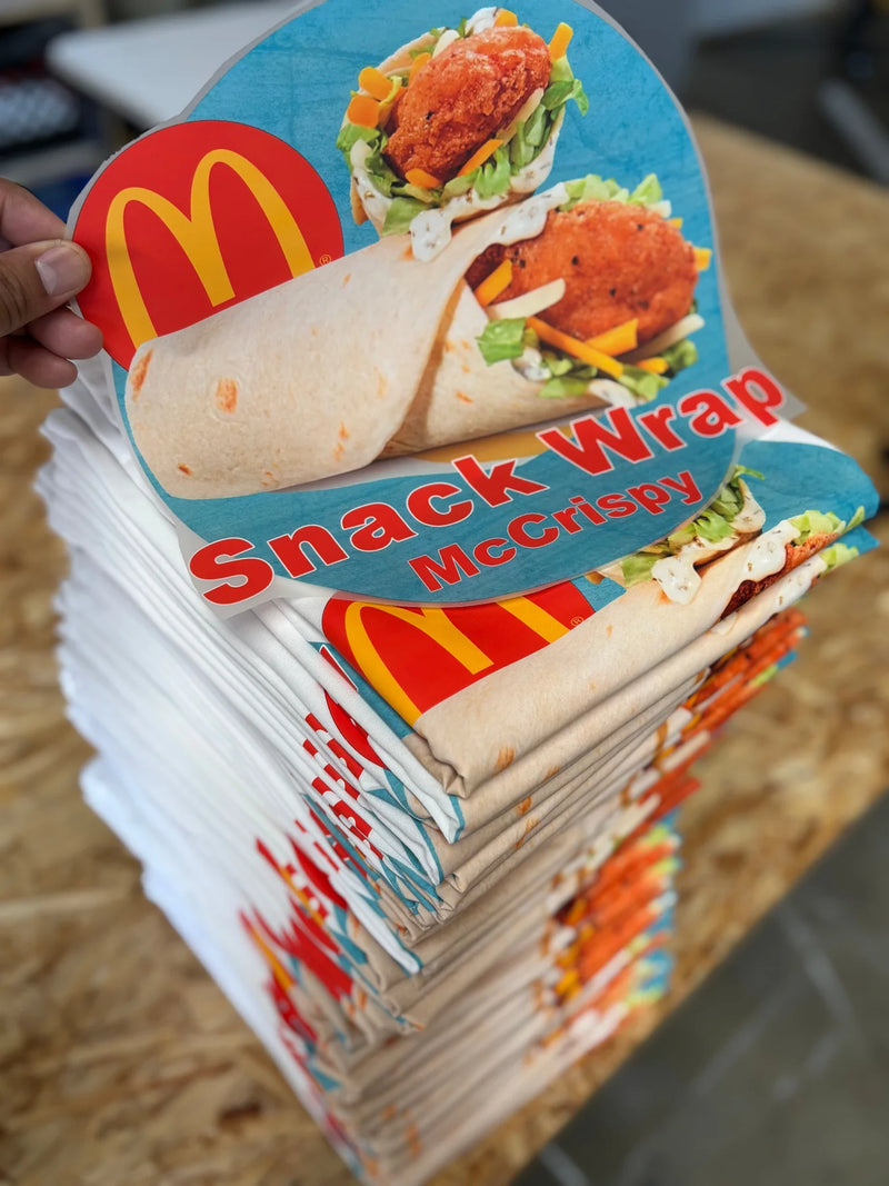 Stack of white restaurant promo t-shirts printed in full color with a menu item graphic for a fast food crew