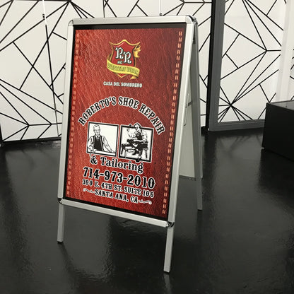 Double-sided A-frame sign with a red leather-style graphic for a shoe repair and western wear business