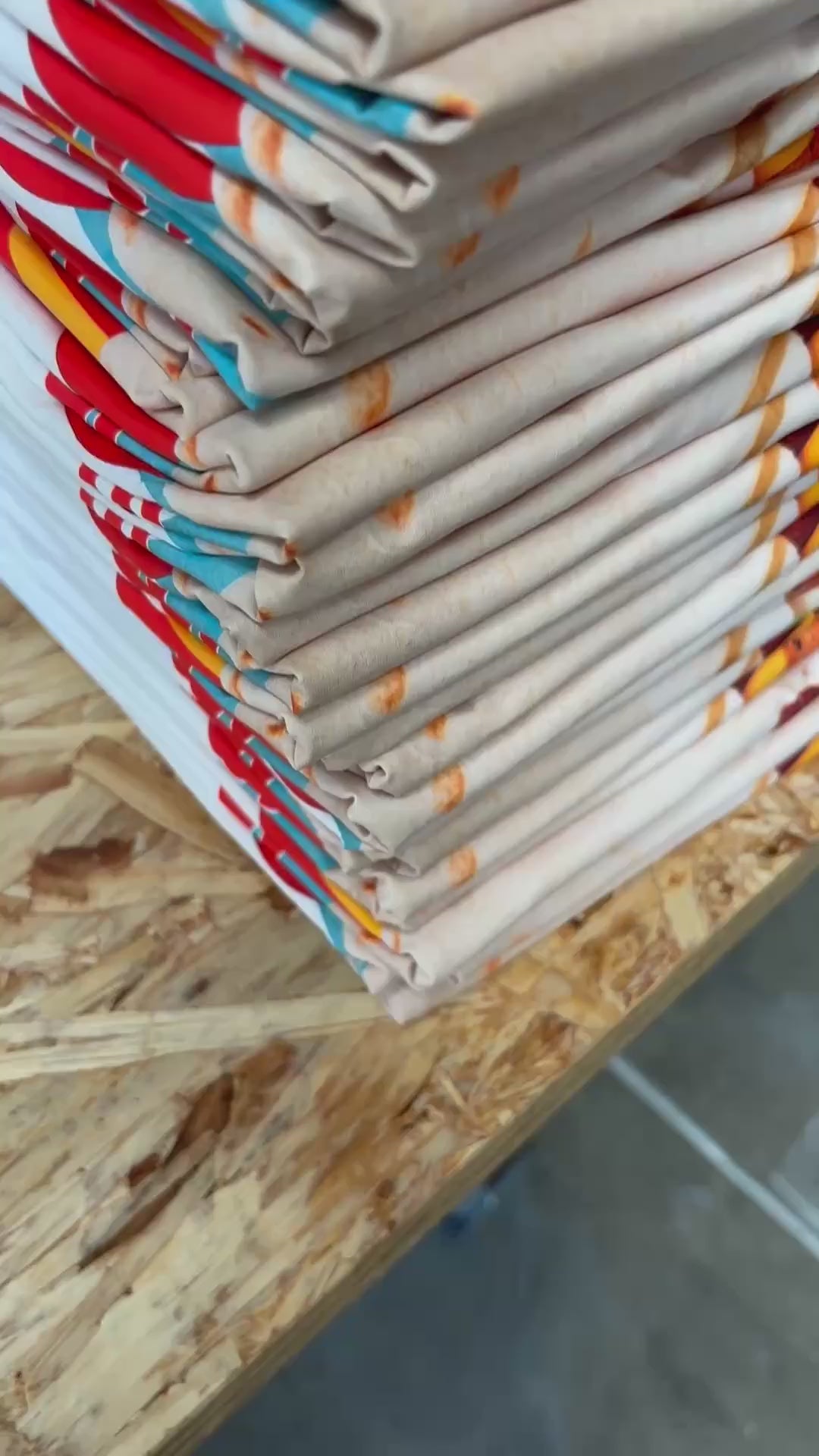 Short video of freshly printed custom t-shirts being stacked and sorted at the Urban Tee LLC print shop in South Gate, CA