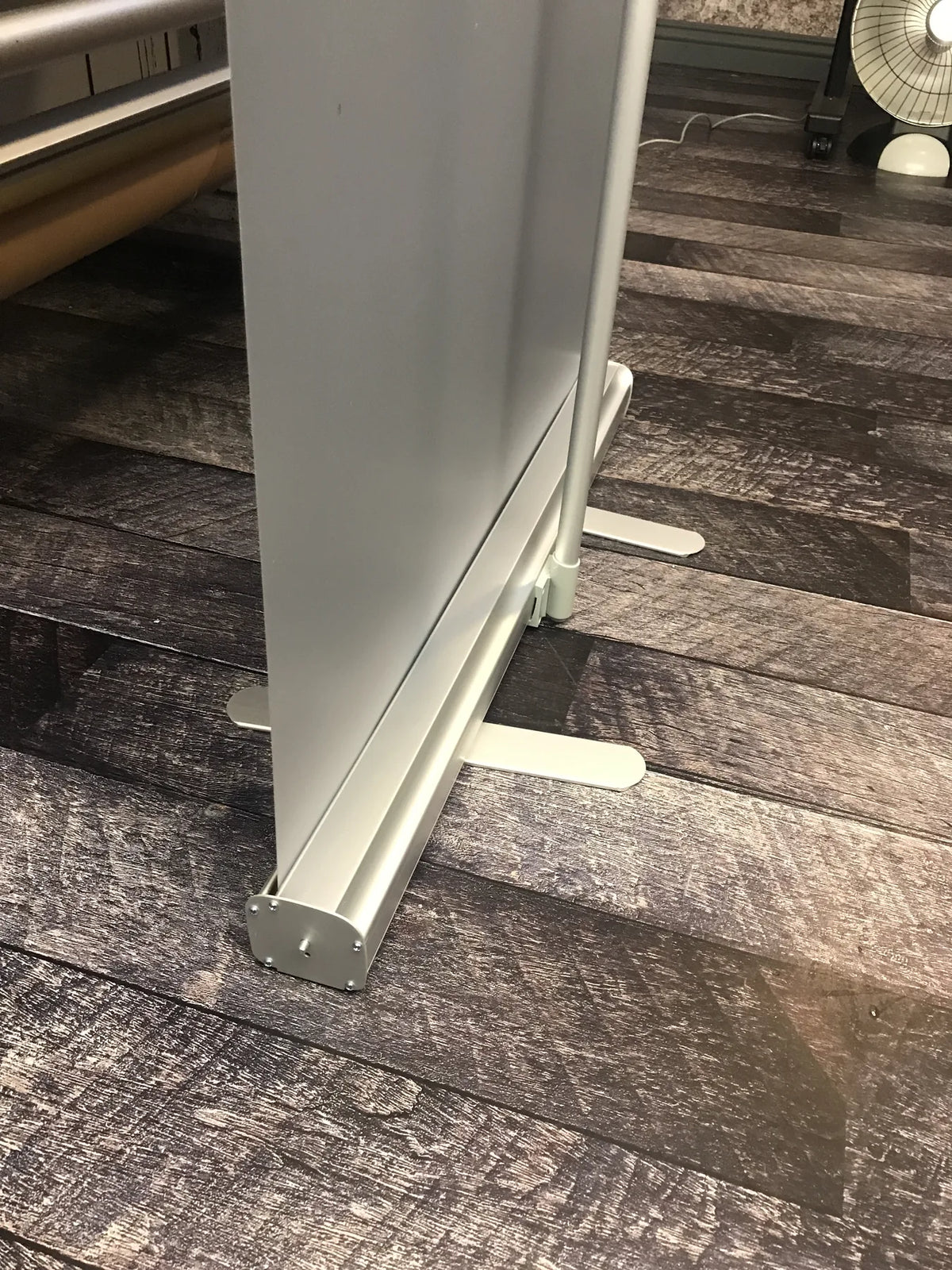 Close-up of the aluminum base and stabilizer feet of a retractable roll-up banner stand
