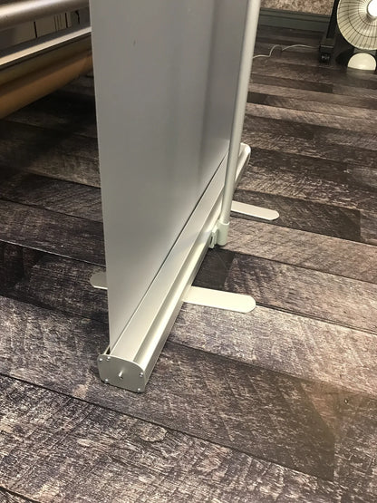Close-up of the aluminum base and stabilizer feet of a retractable roll-up banner stand