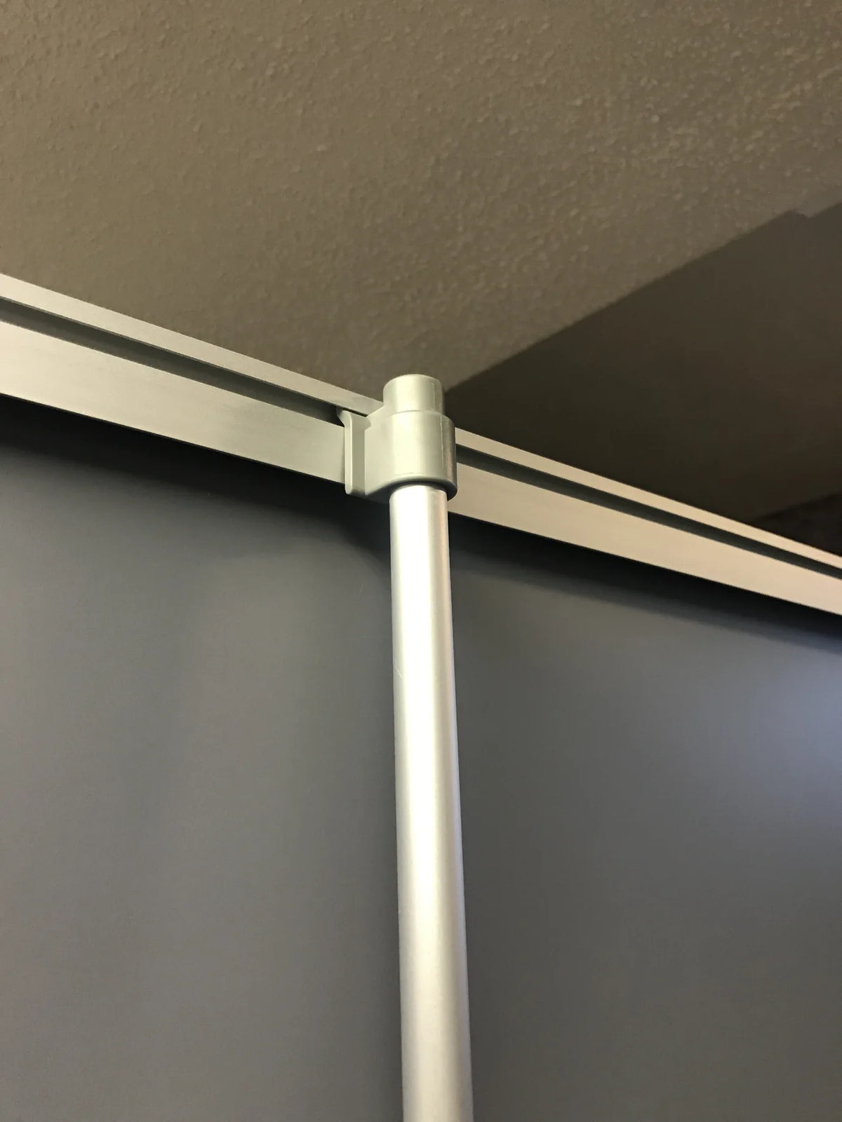 Top rail and telescopic support pole of a roll-up banner stand holding the printed graphic